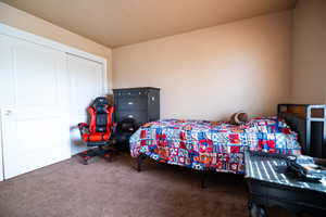 Carpeted bedroom with a closet