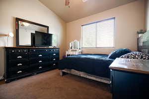 Carpeted bedroom with lofted ceiling