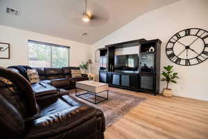 Living area featuring vaulted ceiling, wood finished floors, and ceiling fan