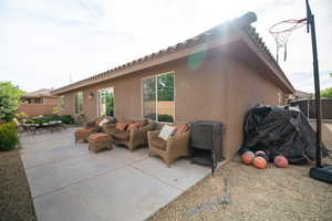 View of property exterior featuring a patio, stucco siding, and an outdoor living space