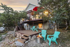 Rear view of property with a fire pit, a wooden deck, and stairway