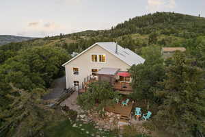 Back of house with a deck with mountain view, a forest view, and stairs