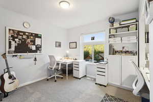 Office area featuring light carpet and baseboards