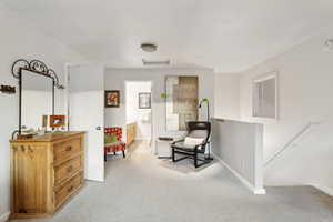 Sitting room featuring carpet flooring and baseboards