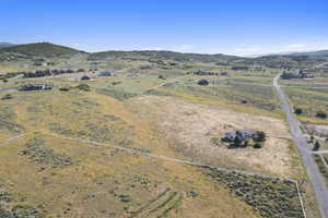 Aerial view of property and surrounding area featuring a mountainous background and rural landscape