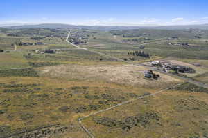 Aerial view of property and surrounding area featuring rural landscape and a mountainous background
