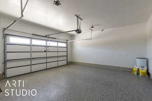 Garage with baseboards and a garage door opener