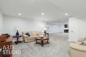 Carpeted living area featuring recessed lighting and a fireplace