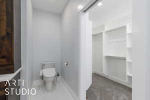 Bathroom featuring toilet and a walk in closet