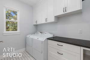 Washroom featuring separate washer and dryer and cabinet space