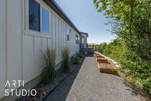 View of side of property featuring board and batten siding and a garden