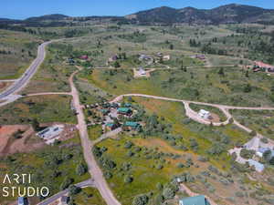 Aerial overview of property's location featuring a mountainous background and rural landscape