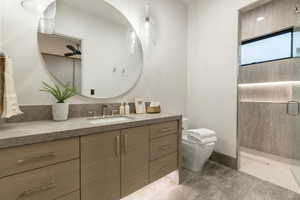 Full bath with vanity, a shower stall, tile patterned flooring, and a ceiling fan