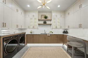 Kitchen featuring separate washer and dryer, backsplash, open shelves, glass insert cabinets, and recessed lighting