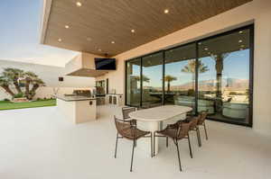 View of patio with area for grilling and outdoor dining area
