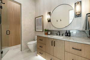 Full bath featuring vanity, a shower stall, and tile walls