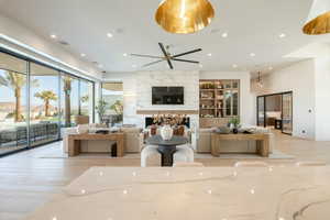 Living area with light wood finished floors, a premium fireplace, recessed lighting, and a ceiling fan