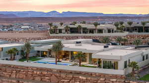 Rear view of house with a patio area, a mountain view, stucco siding, and an outdoor pool