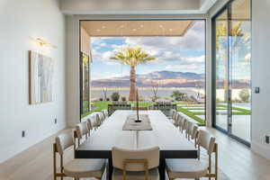 Dining area with wood finished floors, floor to ceiling windows, and a water and mountain view
