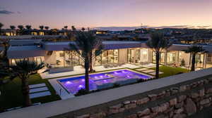 Back of property featuring a patio area, stucco siding, outdoor lounge area, and a pool with connected hot tub