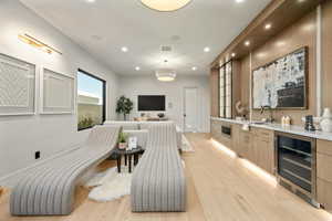 Bar area featuring light wood-style flooring, wine cooler, recessed lighting, and pendant lighting