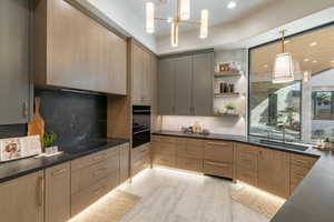 Kitchen with dark countertops, open shelves, decorative backsplash, hanging light fixtures, and recessed lighting