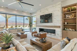 Living area featuring a fireplace, ceiling fan, and recessed lighting