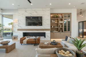 Living area with a premium fireplace, recessed lighting, and carpet flooring
