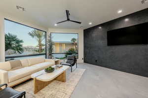 Living area with an accent wall, ceiling fan, and recessed lighting
