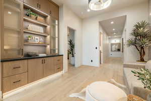 Hallway with light wood finished floors and recessed lighting