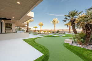 View of yard with a putting green, an outdoor kitchen, a patio area, and a pool