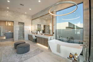 Full bath with vanity, a freestanding bath, recessed lighting, marble tiled floors, and a shower