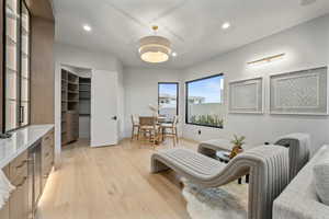 Living room featuring light wood-type flooring, recessed lighting, and wine cooler