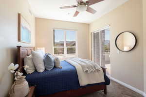 Carpeted bedroom featuring access to exterior and a ceiling fan