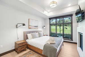 Bedroom with light wood-style flooring, a fireplace, and recessed lighting