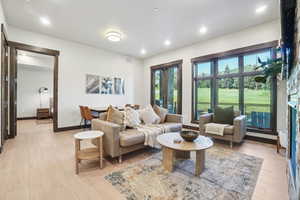 Living area with a fireplace, light wood finished floors, and recessed lighting