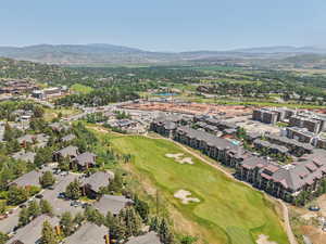 Aerial view of property's location with a mountainous background and a golf course