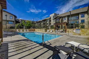 Community pool featuring a patio area, a residential view, and a pergola