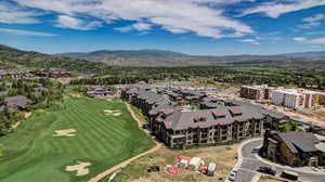 Aerial perspective of suburban area featuring a mountain backdrop and a local golf course