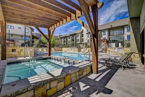 Community pool with a hot tub and a patio area