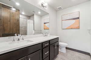 Bathroom with double vanity, tile patterned flooring, a shower with shower curtain, and recessed lighting