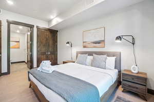 Bedroom featuring light wood-style floors and ensuite bath