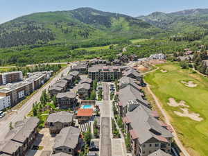 Aerial perspective of suburban area featuring mountains and a golf club