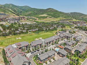 Aerial view of property's location featuring a mountain backdrop and nearby suburban area