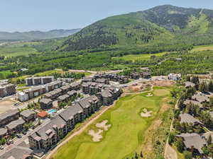 Aerial view of property's location with a mountainous background and a golf course