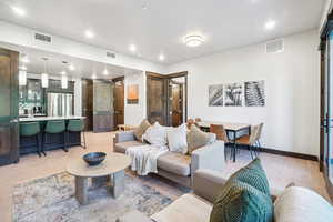 Living area with light wood-style floors and recessed lighting