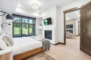 Bedroom featuring a fireplace and light wood-style flooring