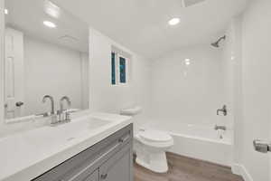 Bathroom with  shower combination, vanity, light wood-style flooring, and recessed lighting