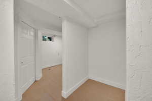 Below grade area featuring a textured wall and light tile patterned floors