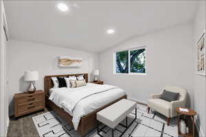 Bedroom featuring vaulted ceiling, recessed lighting, and wood finished floors